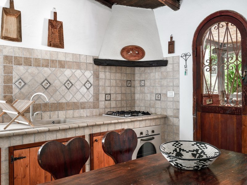 Küche im Landhausstil mit Ofen und Herd und Esstisch aus Holz Küche im Landhausstil mit Ofen und Herd und Esstisch aus Holz