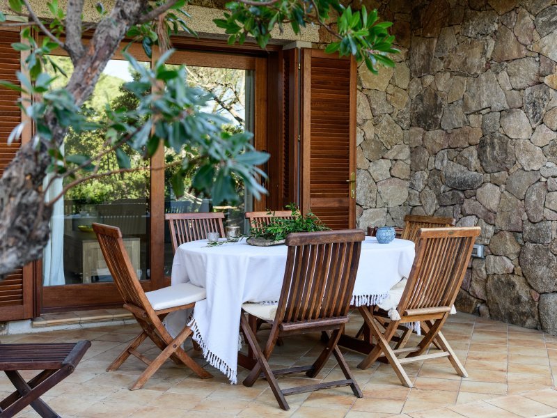Terrasse mit großem Teaktisch zum Essen im Freien Terrasse mit großem Teaktisch zum Essen im Freien