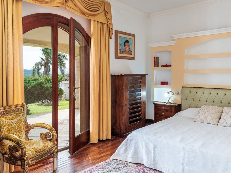 1. Schlafzimmer im Erdgeschoß mit Doppelbett und Türe zum Garten