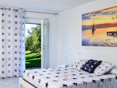 Schlafzimmer 3 im UG mit Doppelbett und Tür zum Garten