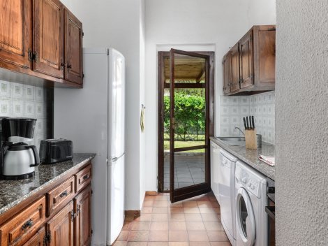Küche mit Waschmaschine, Spülmaschine und direktem Zugang zur Terrasse
