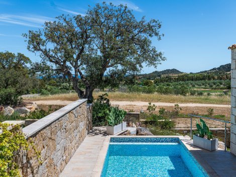 Blick vom Pool auf eine unbebaute Landschaft bis zum Meer