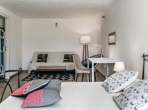 Sitzecke und Schreibtisch teilen das Schlafzimmer in einen Lounge- und Schlafbereich