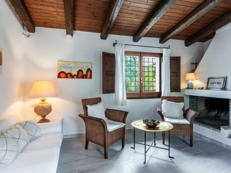 Das Wohnzimmer ist gemütlich eingerichtet mit gemauerter Sitzbank und einem Innenkamin